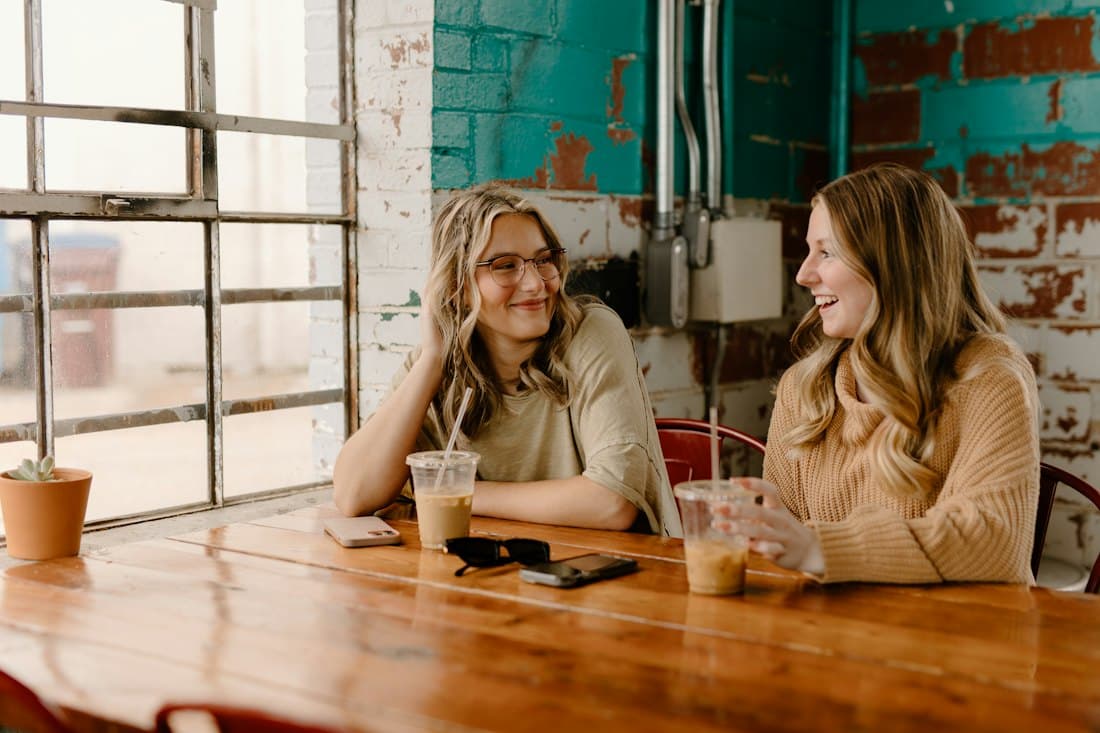 Duas mulheres conversando com um café